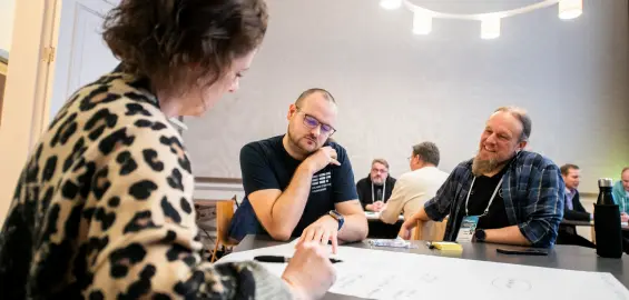 Members of the ORC community collaborating around a whiteboard.